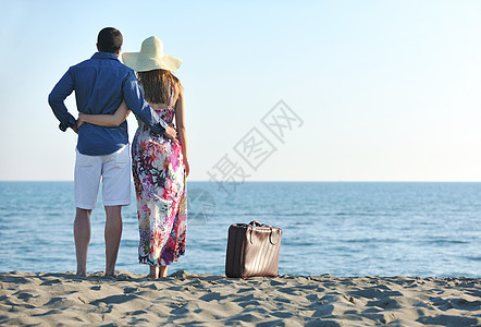 夫妇海滩上带着旅行袋,代表自由趣的蜜月图片