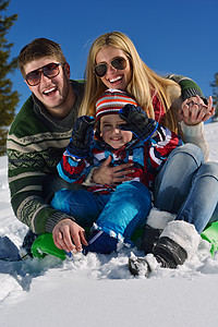 家庭场景冬季快乐的家庭假期的新鲜雪上玩得开心背景