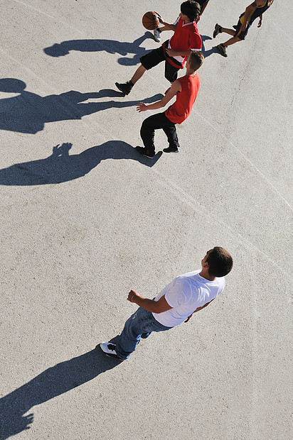 轻男孩户外打篮球,长阴影鸟瞰视角