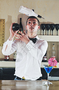 专业酒吧服务员准备鸡尾酒饮料,并代表夜生活派活动的图片