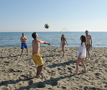 排球馆轻人体玩得开心,阳光明媚的夏日打沙滩排球背景