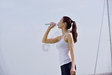 美女 饮酒轻的美女健身运动户外慢跑后喝水背景