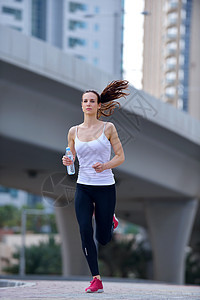 城市公园跑步早上外慢跑的女子跑步者,背景迪拜城市的场景图片