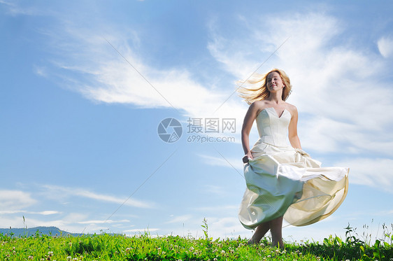 婚礼后,快乐的轻美丽的新娘日落的草地上玩得很开心图片