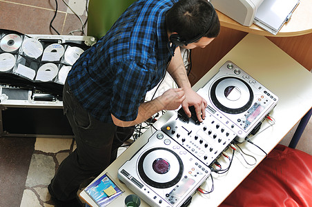 轻的DJ男子戴着耳机光盘DJ设备参加聚会图片