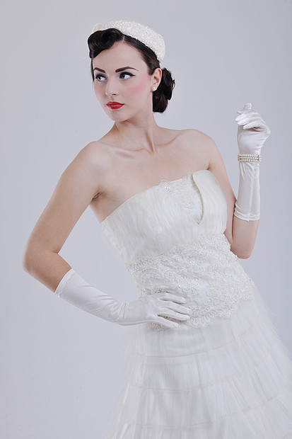 美丽的轻新娘穿着复古时尚风格的婚纱,隔离工作室的白色背景上图片