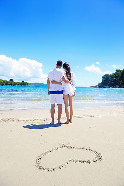 快乐的轻夫妇玩得开心,夏天放松,心沙滩上画画图片
