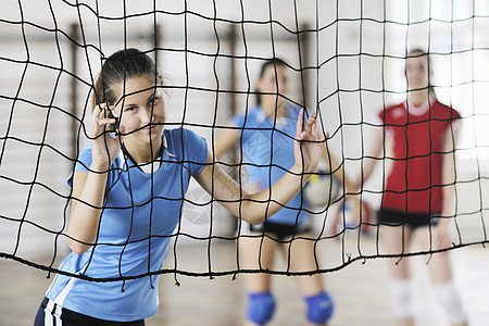 排球运动与群轻漂亮的女孩室内运动竞技场图片