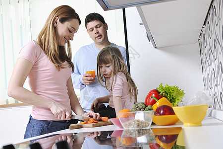 室内儿童游乐场幸福的轻家庭午餐时间与新鲜的水果蔬菜食物明亮的厨房背景