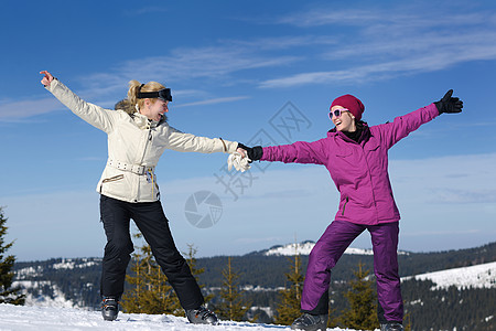 快乐的朋友们,群女孩子冬天的季节里玩得很开心,美丽的阳光明媚的雪天里,背景蓝天图片
