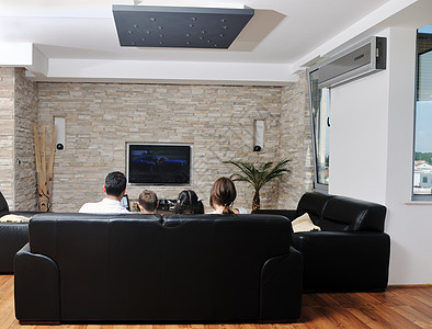 幸福的轻家庭现代家庭室内观看平板电视图片