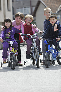 快乐的孩子们美丽的阳光明媚的春天集体学驾驶自行车图片