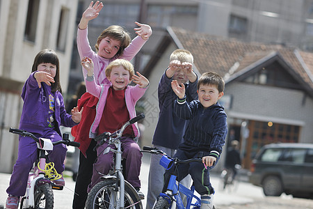 快乐的孩子们美丽的阳光明媚的春天集体学驾驶自行车图片