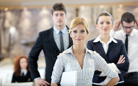 商务妇女站她的员工背景现代明亮的办公室会议室图片