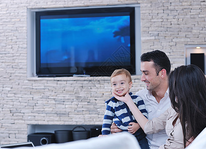 快乐的轻家庭新的家庭乐趣放松与现代液晶电视背景图片