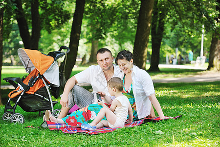 快乐的轻家庭公园放松,并与孕妇玩得开心图片
