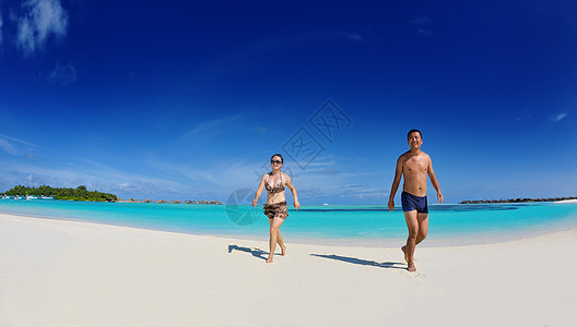 快乐的轻亚洲夫妇美丽的白沙滩上度过快乐浪漫的夏天图片