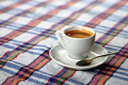 杯咖啡放五颜六色的桌布上图片