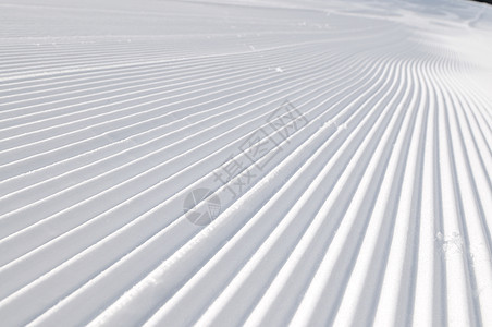 美丽的阳光明媚的冬天,雪坡上的铁轨上蓝天图片