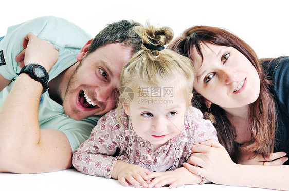 轻幸福的家庭与美丽的婴儿玩耍微笑隔离白色的工作室图片