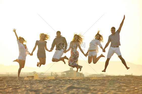 快乐的轻人体乐趣的跑步跳跃海滩美丽的沙滩图片