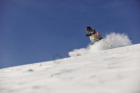 男子滑雪免费骑下山冬季,美丽的晴天粉末雪图片