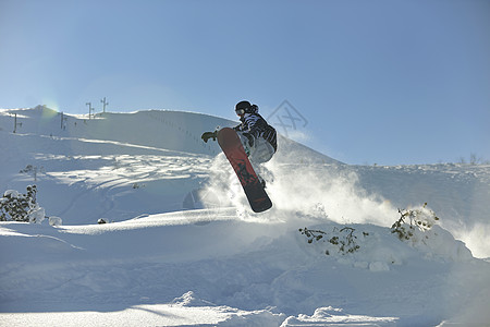 自由式滑雪板跳跃骑自由风格阳光明媚的冬季山上图片