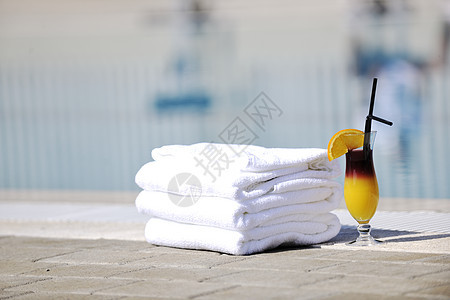 鸡尾酒与橙色ATT晴天游泳池侧与白色毛巾装饰图片