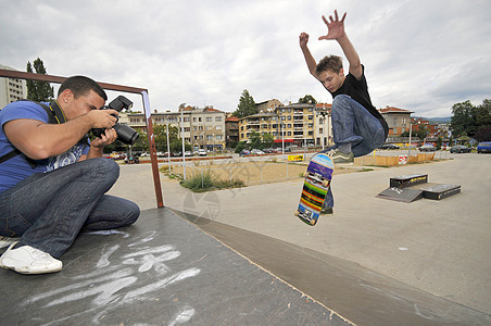 男人公园里拍男孩滑冰的照片图片