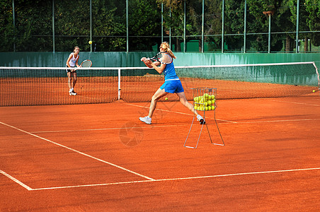 两个轻的女人户外打网球图片