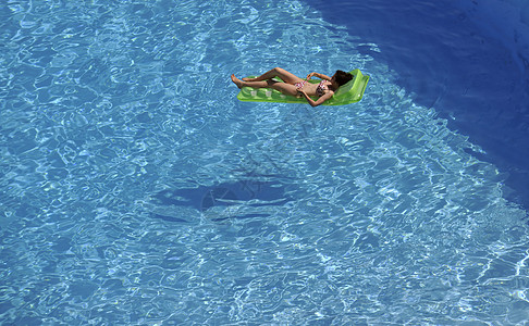 快乐的轻女人度假旅游胜地的游泳池放松图片