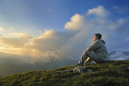 健康的轻人清晨日出时高山上练瑜伽图片