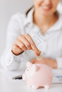 商业,办公室,家庭,学校,税收教育女人手把硬币放进小猪存钱罐图片