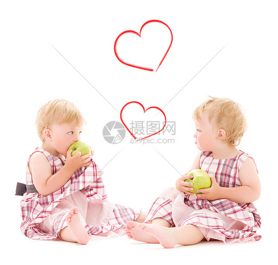 孩子幸福的两个可爱的双胞胎,苹果超过白色图片
