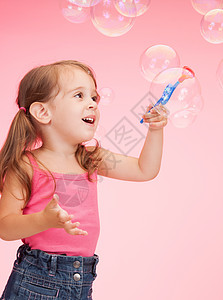 美丽的小女孩用肥皂泡的明亮照片图片
