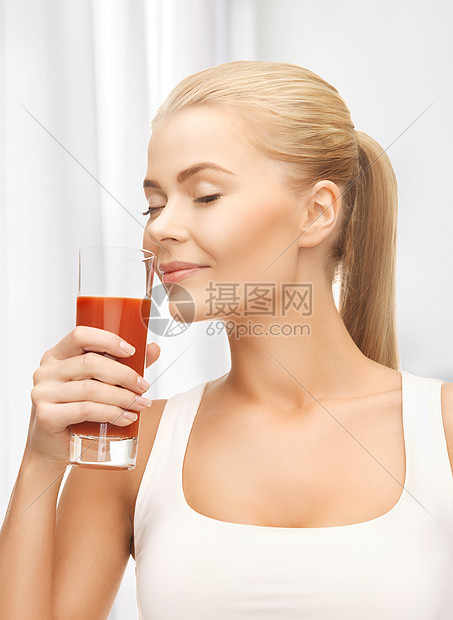 特写年轻女子喝番茄汁图片