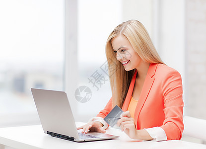 微笑的女商人带着笔记本电脑信用卡图片
