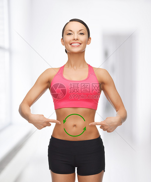 美丽的运动女人的照片,她的胃上箭头图片