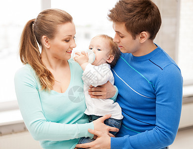 幸福的家庭可爱的婴儿与喂食瓶图片