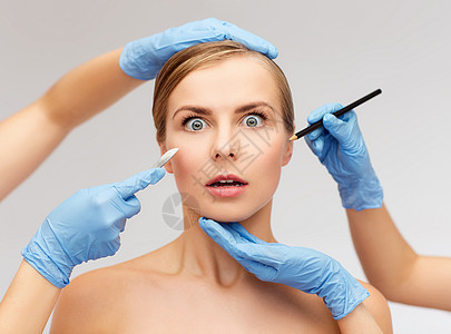 保健,美容医学美丽的女人脸美容师的手与铅笔手术刀图片