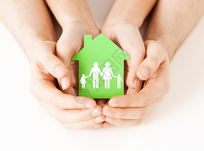 房地产家庭住宅的男女手握绿色纸屋与家庭的特写图片图片