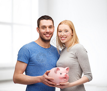 金融,金钱家庭观念微笑的夫妇持大储蓄罐图片