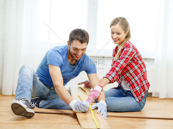 修理,建筑家庭微笑夫妇测量木地板图片