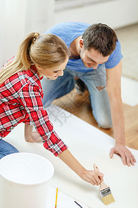 修复,建筑家庭微笑夫妇涂抹壁纸与胶水图片