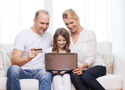 家庭,孩子,技术,金钱家庭微笑的父母小女孩带着笔记本电脑信用卡家图片