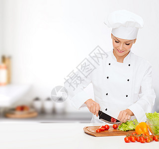 烹饪食物微笑的女厨师,厨师包师切蔬菜图片