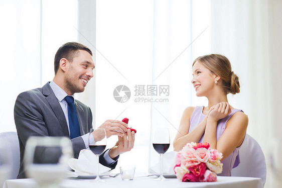 餐厅,情侣节日微笑的男人向他餐馆的女朋友求婚图片