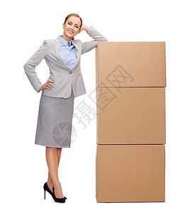 商业,邮政运输微笑的女商人与塔的纸板箱图片