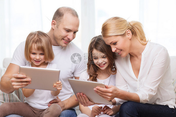 家庭,孩子,技术,金钱家庭微笑的家庭两个小女孩家里平板电脑电脑图片