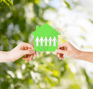 房地产家庭住宅的特写图片,男女手握绿色纸房图片